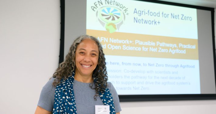 A person stood at the front of the room, smiling, ready to present at the AFN Network+ “Big Tent Event”