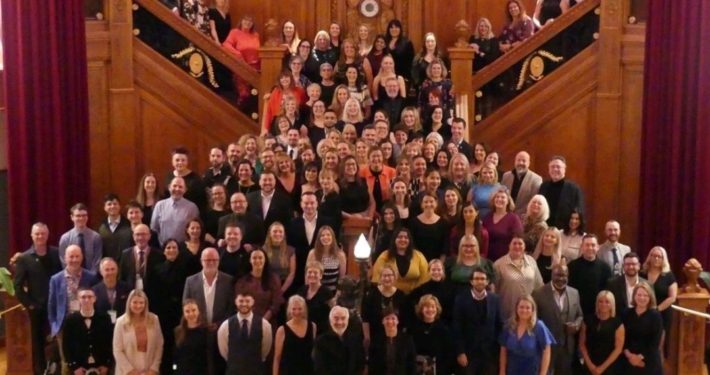All of the attendees at ICCA 2024 in Belfast pose for a group photo on a large staircase