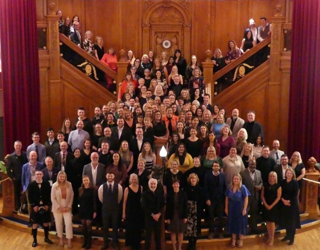 All of the attendees at ICCA 2024 in Belfast pose for a group photo on a large staircase