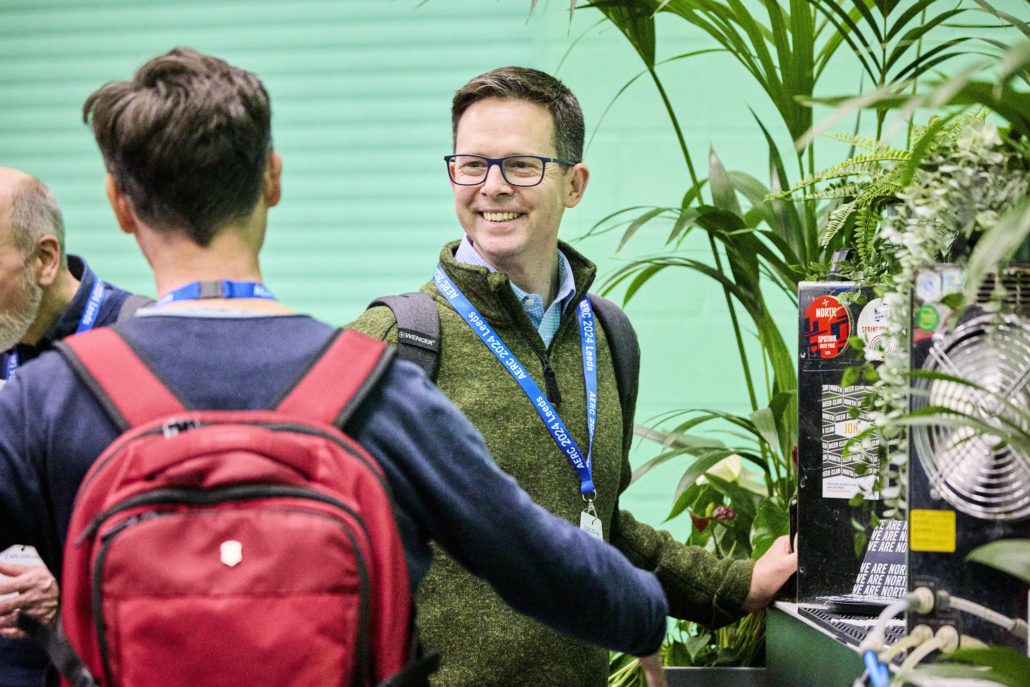 Two people smiling talking to each other at the end of an event 