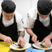 Two chefs working together plating up food