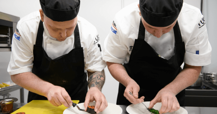 Two chefs working together plating up food