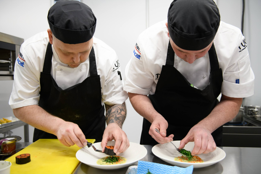 Two chefs working together plating up food